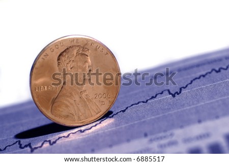 Closeup of pennies with graph and stock chart in background