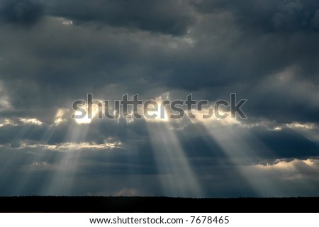 Sunset thunder storm clouds with rays of sunlight