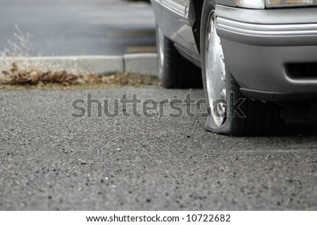 Car parked on a roadway with a flat tire