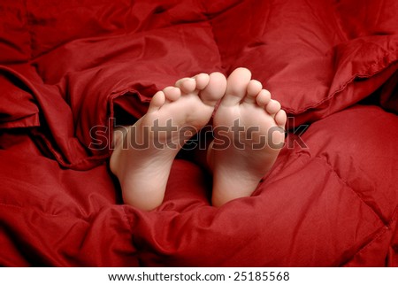 Little girl sleeping with feet poking out of blankets