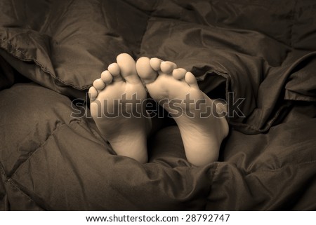One person sleeping with feet poking out of blankets