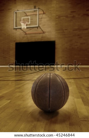 Basketball on floor of empty basketball court