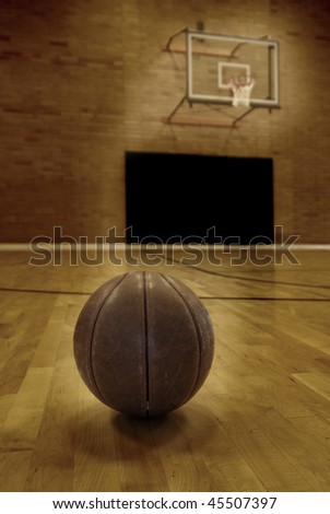 Basketball on floor of empty basketball court