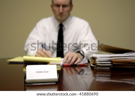 Attorney at Law sitting at desk holding pen with files