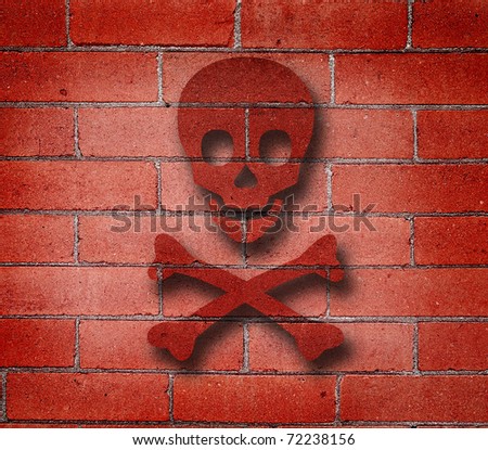 Detail shot of an old red brick wall with graffiti of cross bones