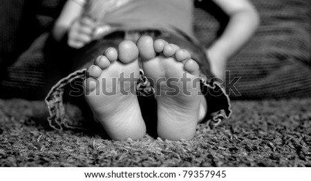 Young Child\'s bare feet on floor of home