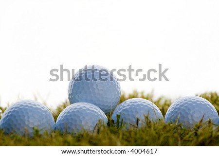 group of golf balls over grass in white background