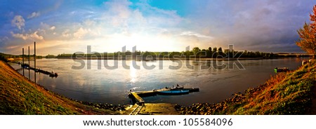 Sunset colours reflected on Po river, Italy\'s biggest river with boats