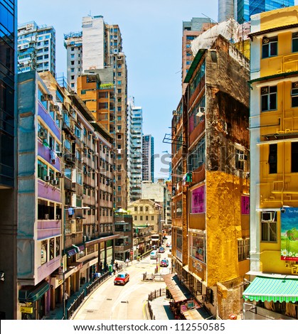 HONG KONG, CHINA - JULY 30, 2012: Street view with taxi and buildings on July 30, 2012 in Hong Kong, China. With 7M population it is one of the most dense areas in the world.
