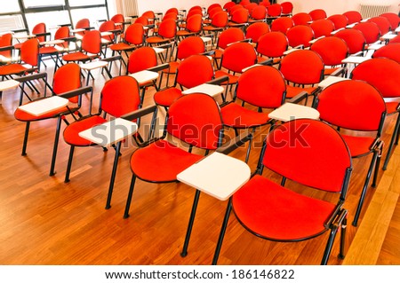 rows of red and white chairs in an empty modern conference room