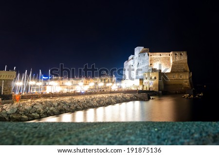 NAPLES, ITALY - JANUARY 1, 2014: night view of boardwalk buildings and Castel dell\'Ovo in Naples, Italy. Naples is the the third-largest city in Italy with about 1 million residents.