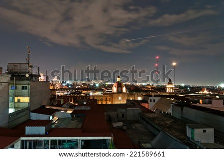 MEXICO CITY, MEXICO - APRIL 29, 2014: night view of skyline with brightly lit suburban barrios in the background in Mexico City, Mexico. The city is located at an altitude of 2,240 metres.