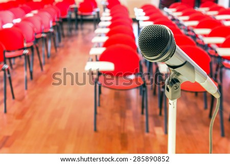Close up of microphone in front of empty chairs in conference room