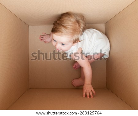Little child inside cardboard box with a strongly expressed perspective view.