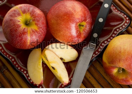Red Royal Gala apples on a plate with a knife