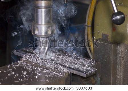 Milling machine is cutting metal with lot of smoke