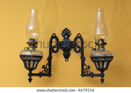 Antique lantern placed on outside wall with shadow