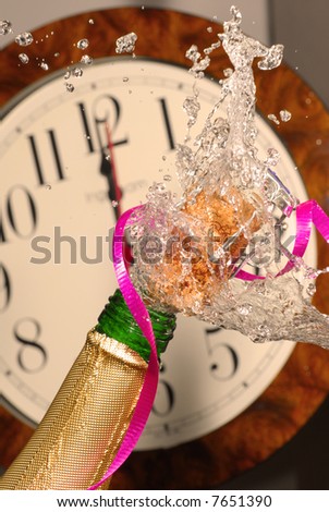 Close-up of explosion of Christmas champagne bottle cork with clock strikes midnight