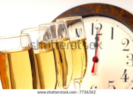 Glasses of champagne with ribbons and clock strikes midnight