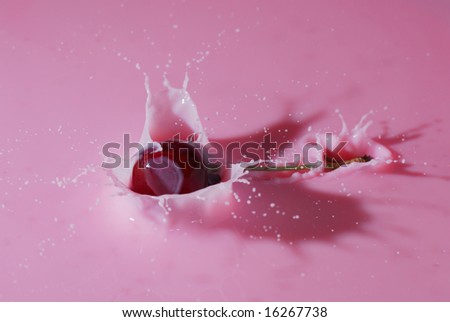 An extremely close view of a cherry splashing into pink milk