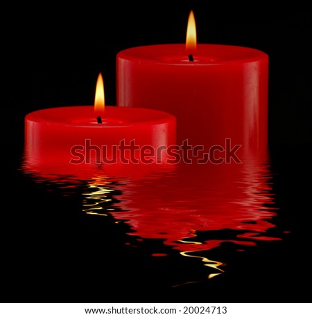 Two candles studio isolated on dark background with reflection