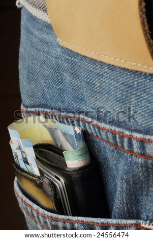 Wallet in back pocket of jeans with money sticking out
