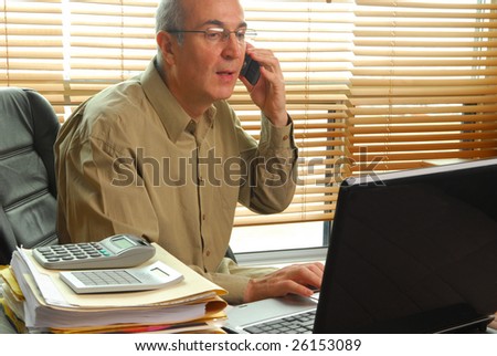 Businessman working with laptop and calling by cell phone
