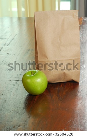 Lunch bag and apple placed on a table ready to go