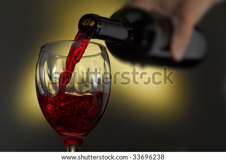 Red wine pouring into a glass, with abstract background