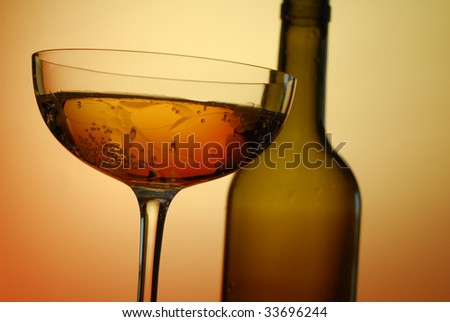 Abstract image of a glass of wine from below with a bottle in the distance