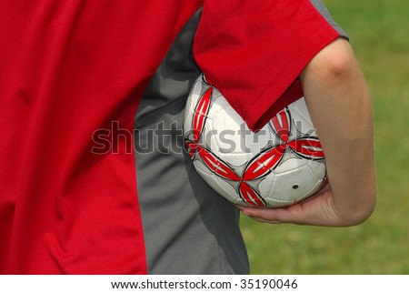 Image of a young female soccer player holding a soccer ball