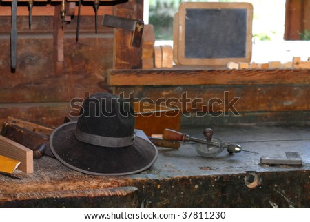 An old carpenter?s hat left on an old wooden workbench