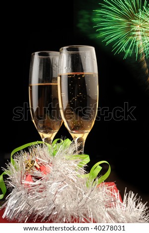 Champagne flutes and Christmas setting with firework in distance
