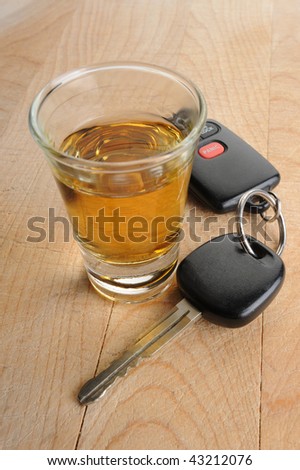 Do not drink and drive - glass of liquor and car keys on white