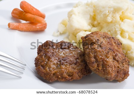 Two meat patties with mashed potato and carrot