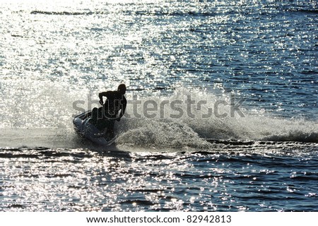Man on Jet Ski turns fast on the water