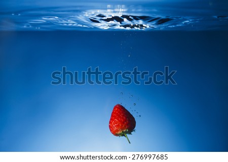 Single Strawberry dropped in water tank