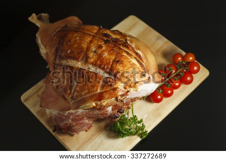 Honey glazed ham on black glossy surface