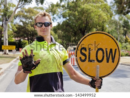 Road worker slows traffic with hand and sign