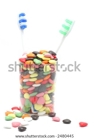 stock photo : two toothbrushes in a cup filled with heart shaped candy