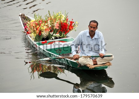 SRINAGAR, JAMMU AND KASHMIR, INDIA - JULY 20, 2006: Flower seller on Dal Lake in Srinagar rowing his floating flower shop