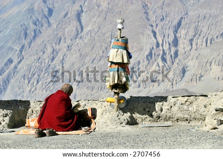 Buddhist monk reading a religious text with Himalaya mountains background