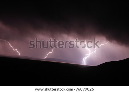 Lightning strike in the darkness over mountains