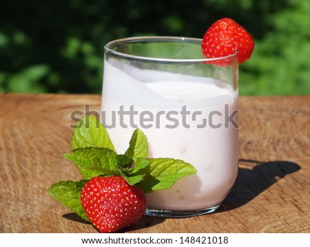 yogurt with fruit on a board made ??of oak wood in the garden