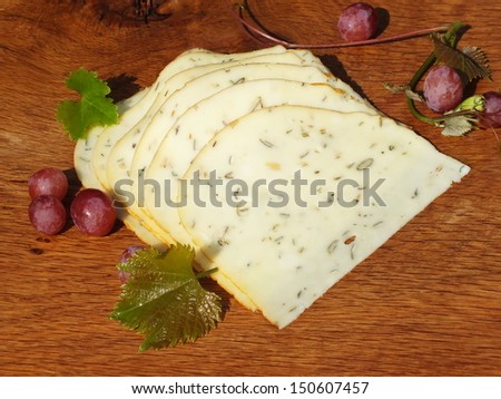 freshly cut slices of cheese on an oak board