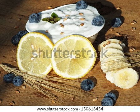 Yogurt with fruit on a board of oak in the garden