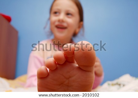 stock photo Foot of a young girl sitting on a bed