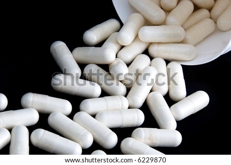 Load of white pills spilling from white pill container II