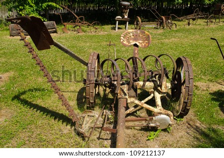 Vintage rusty grass cutting and harvesting agricultural machinery equipment.