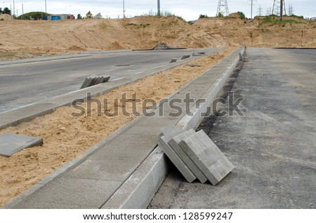 new highway asphalt road construction works. pavement tiles on new sidewalk.